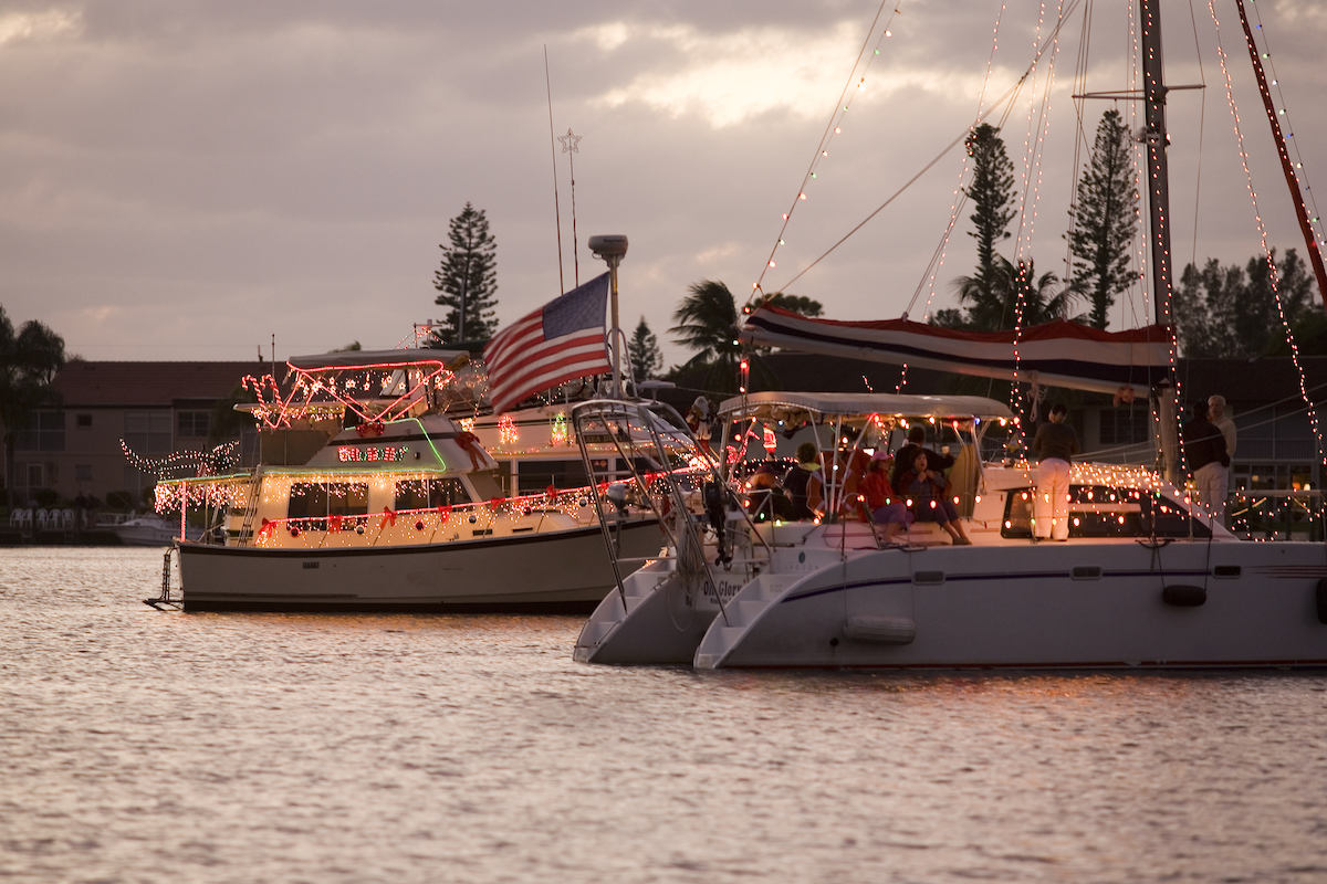 Two boats float down a canal in Cape Coral decorated in holiday lights and decor for the annual boat parade.