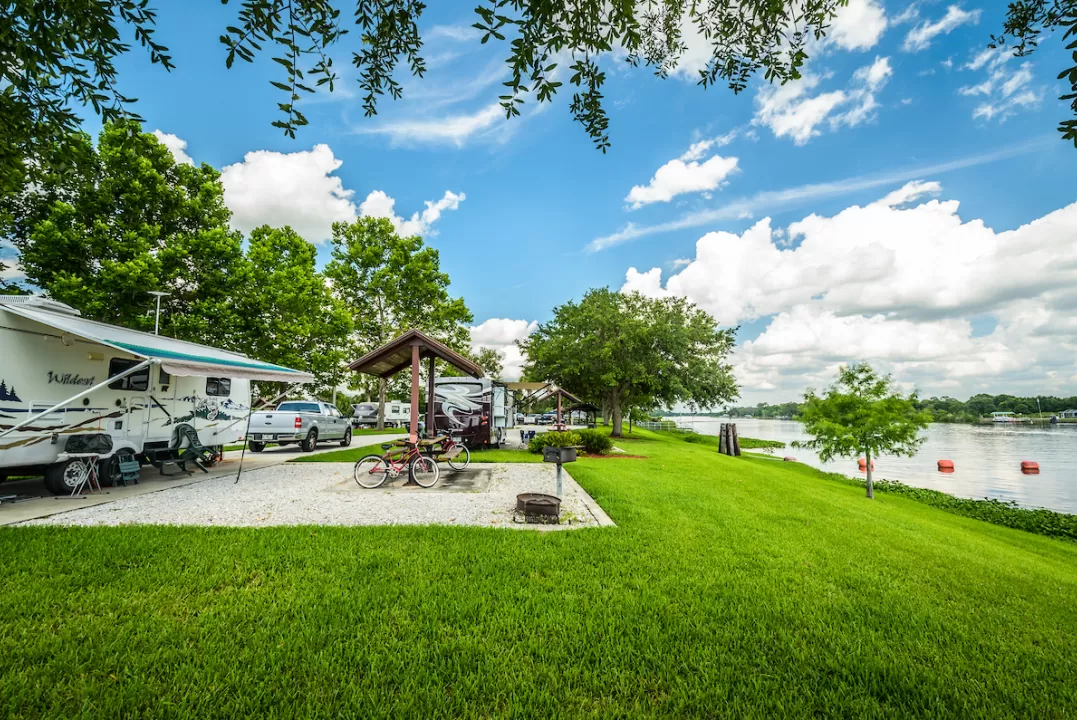 campground with camper, green grass by the water