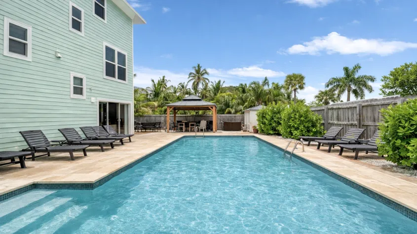 Southern Serenity FMB vacation rental with private heated pool, lounge chairs, and tropical outdoor living space on Fort Myers Beach.