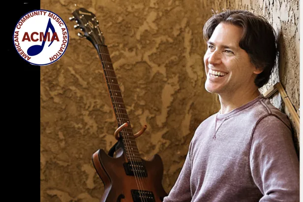 Fran Snyder leans against a wall, guitar in background.  ACMA logo in corner.
