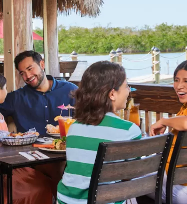 A family enjoys at meal on an outdoor deck at Coconut Jacks in Bonita Springs