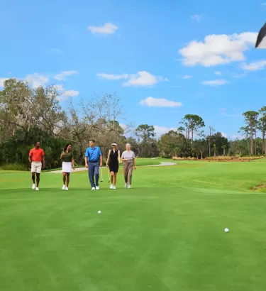 A group walks down the green on a Golf course
