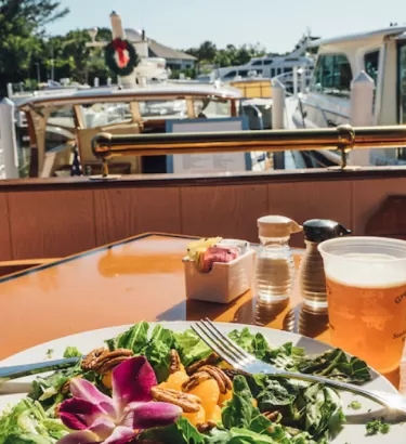 A salad and a beer are set at a table at a marina on Sanibel Island