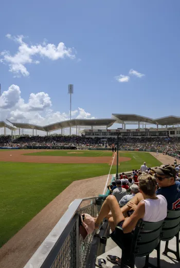 Fans watch a baseball game at JetBlue Park in Fort Myers under a bright blue sky.