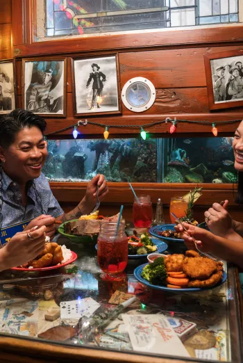 A family shares a meal at The Bubble Room on Captiva Island surrounded by colorful lights and vintage photos.