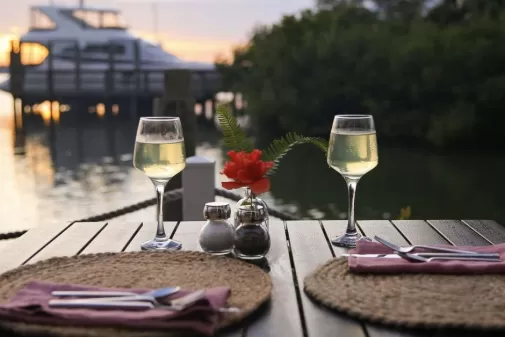 wine glasses on the water with boat in background