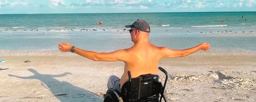 guy sitting in wheelchair on the beach