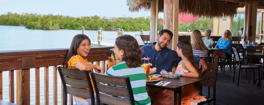 A family enjoys at meal on an outdoor deck at Coconut Jacks in Bonita Springs