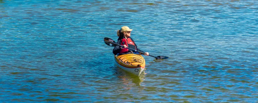 A person in a kayak in the middle of a lake