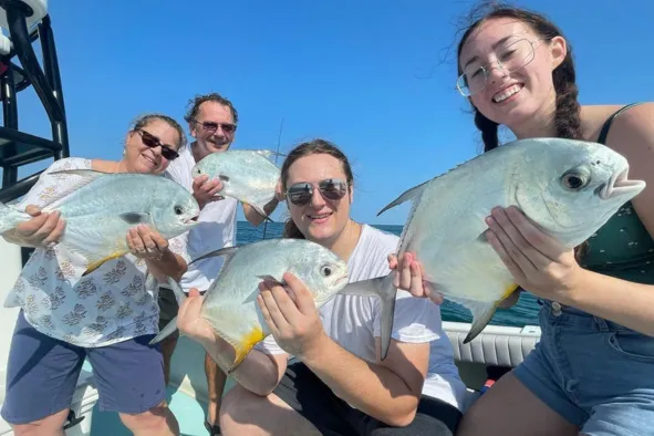 A family shows off their prize catches of fish