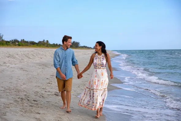 A couple walks along a beautiful secluded beach
