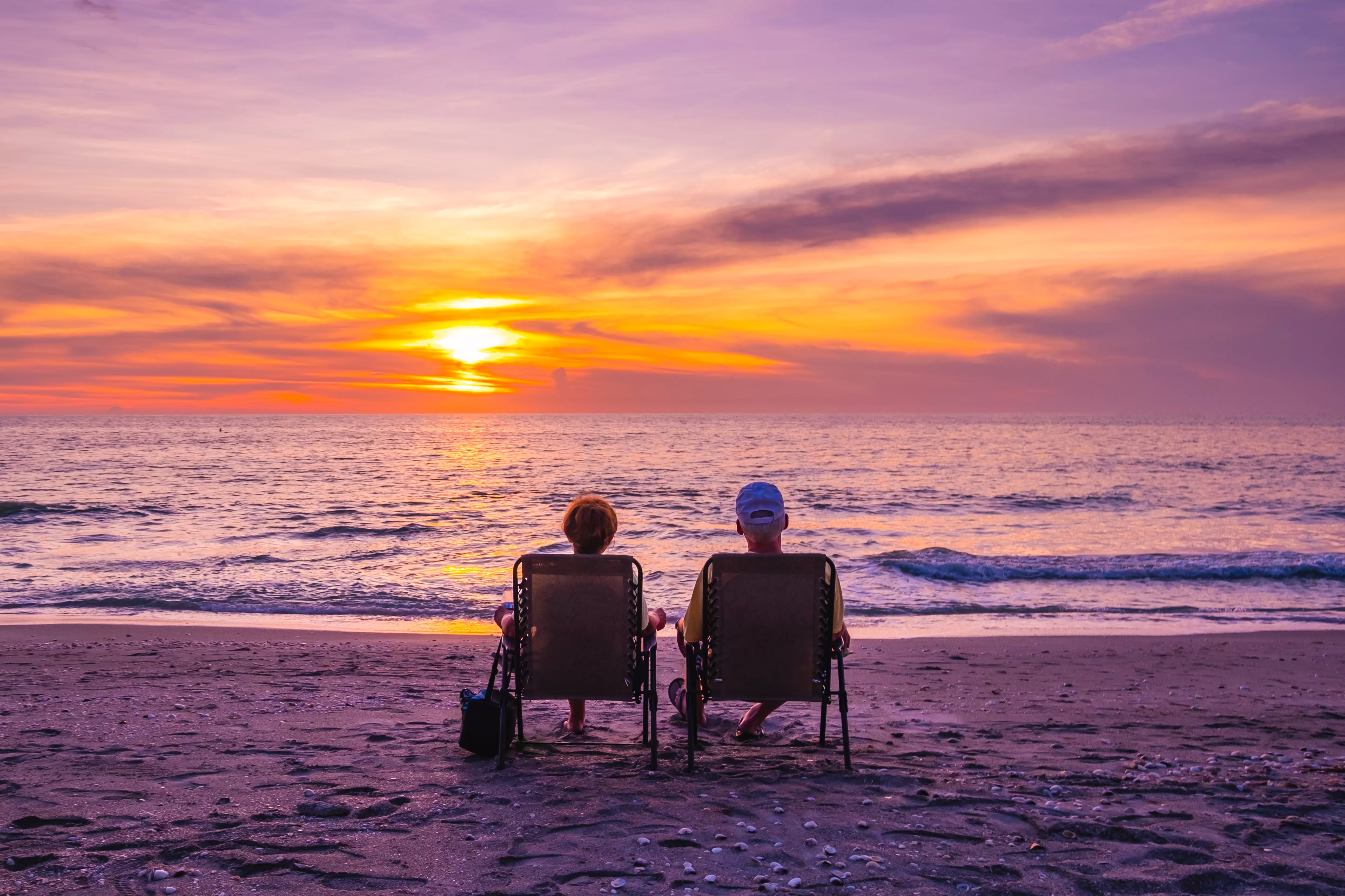 couple sitting on beach watching the sunset